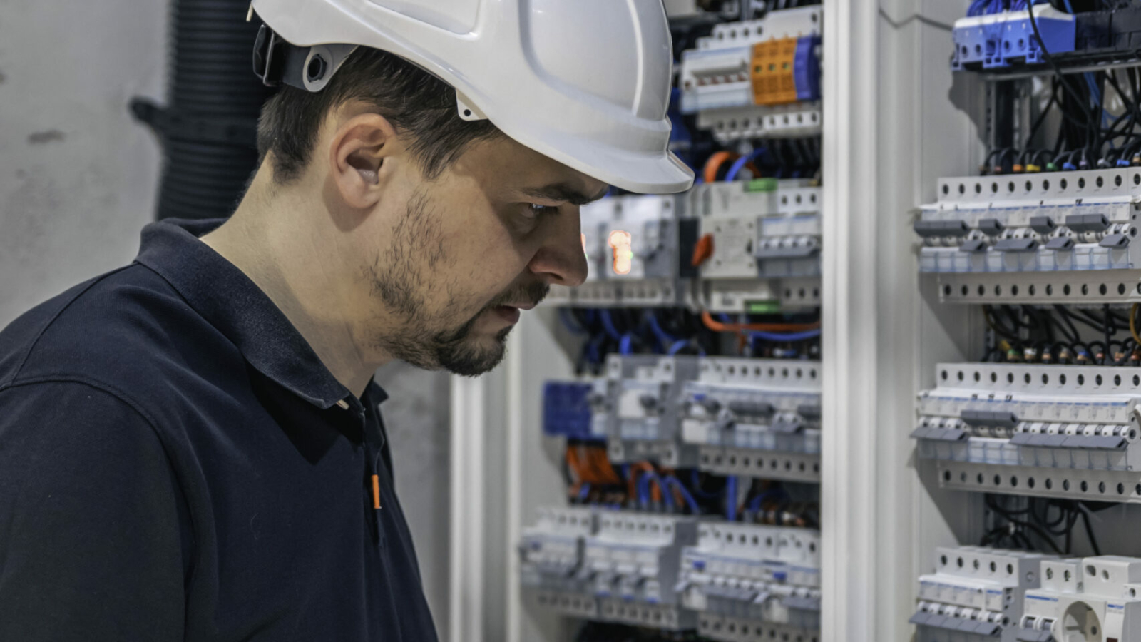 Électricien travaillant sur un tableau électrique avec fusibles